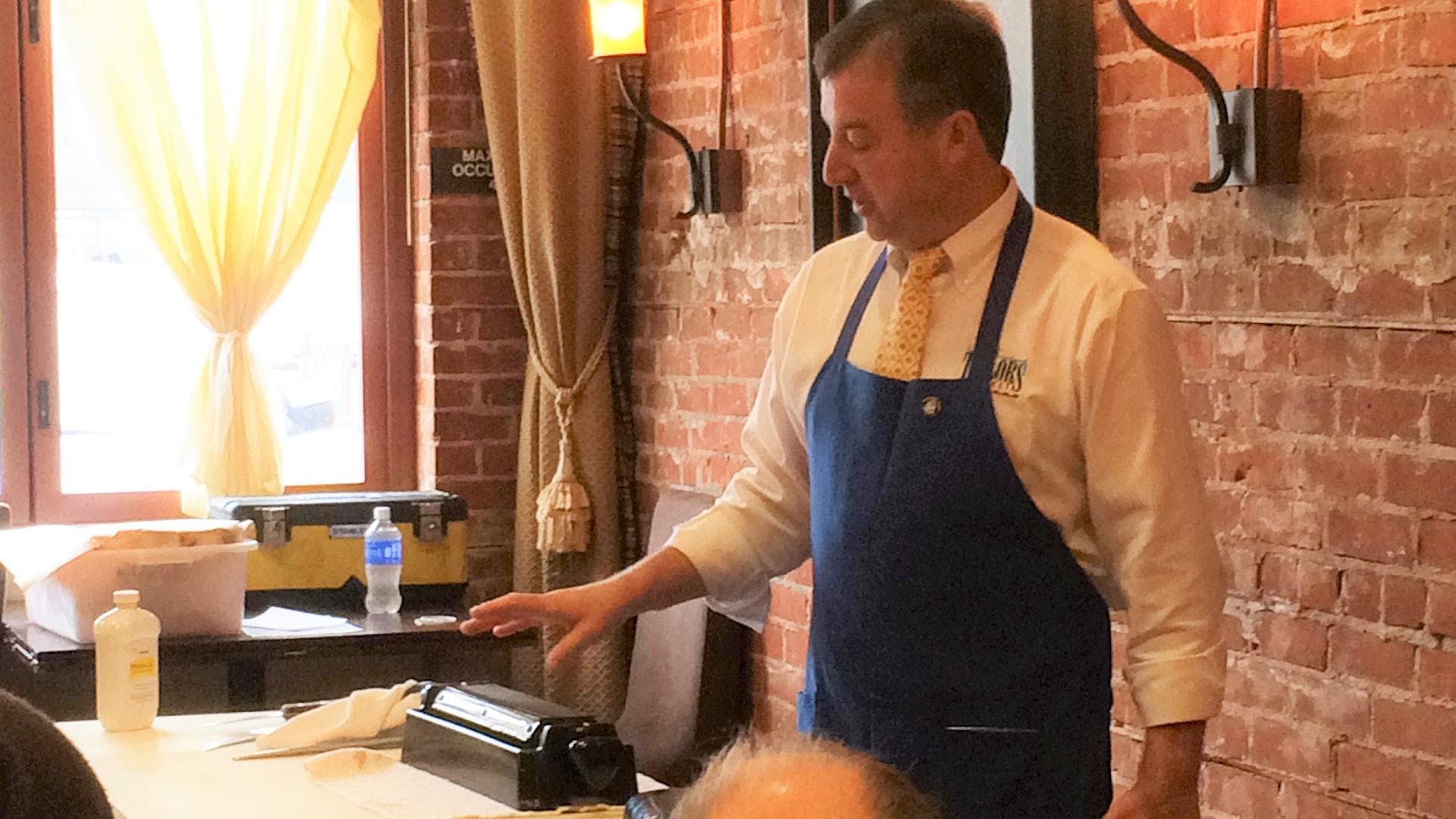 image of man standing in front of pasta maker